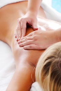 Massaging women's right shoulder.